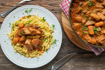 Delicious and healthy chicken stew or ragout with vegetables and brown sauce fresh and homemade cooked  on wooden table