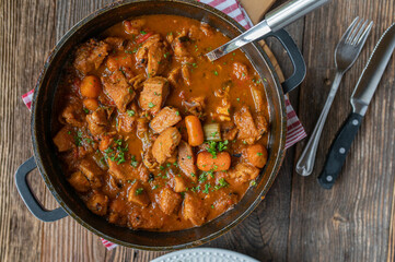 Delicious and healthy chicken stew or ragout with vegetables and brown sauce fresh and homemade cooked  on wooden table