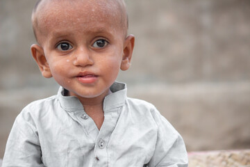 Abandoned Child Eating Bread in Traditional Attire in Refugee Camp