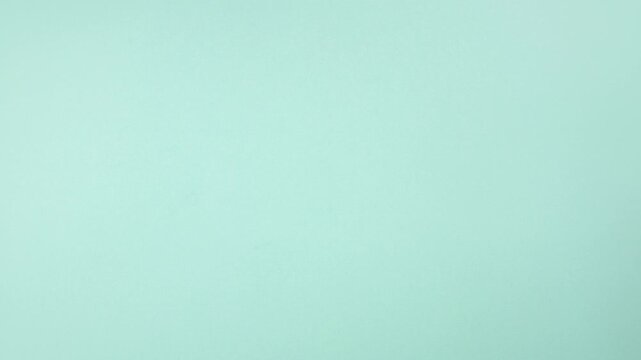 Loop animation. Flat lay school supplies on the table, frame of supplies mint green background. Copy space for text. Back to school, office concept, flat lay stop motion animation footage video