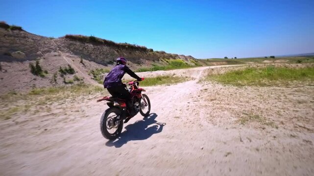 An enduro racer rides a cross-country bike with tricks at his home spot. Speedrump. FPV shot from drone motorcycle cross extreme sport adventure. Filmed on a sports FPV drone quadcopter