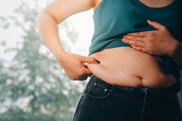 fat woman, fat belly, chubby, obese woman hand holding excessive belly fat with measure tape, woman diet lifestyle concept