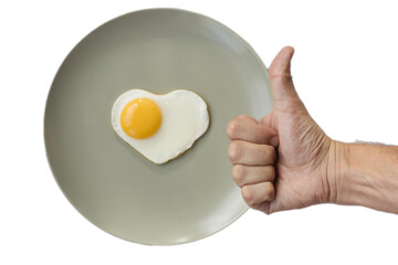 A male gives a thumbs up against the background of a fresh soft-boiled egg on a pistachio plate, symbolizing the concept of healthy eating and a good start to the day, isolated on white.