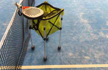 Padel balls on court in basket