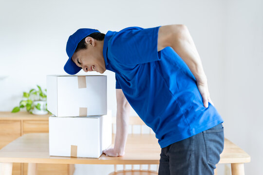 部屋で腰を痛める男性