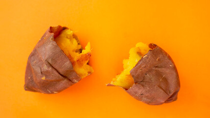 Baked sweet potato on the orange background. オレンジ色背景上の焼き芋（サツマイモ）