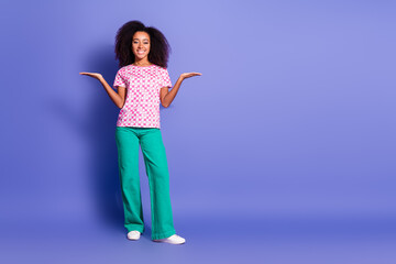 Photo of adorable positive nice woman wear trendy clothes hold empty space isolated on purple color background