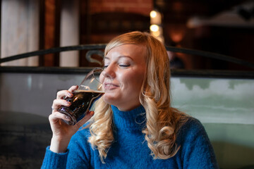Happy woman drinking beer in pab. Closeup portrait.