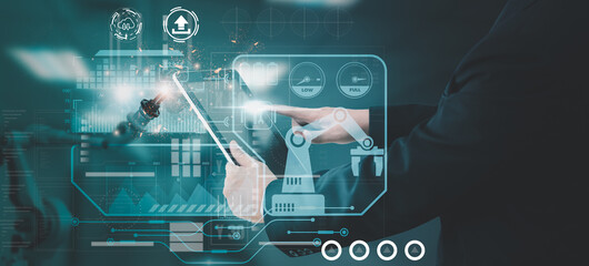 Industry engineer in factory,using smart tablet device,control automated robot arm machine learning operation,concept business and industry 4.0,Artificial intelligence or AI,with 5G network