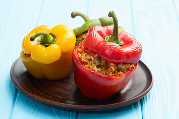 Baked stuffed pepper ( paprika ) with rice , carrot and meat . Top view on rustic background