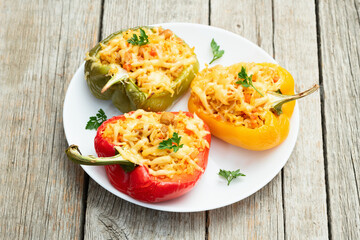 Baked stuffed pepper ( paprika ) with rice , carrot and meat . Top view on rustic background