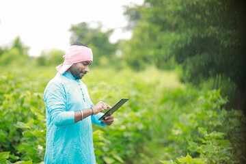 happy young Indian farmer using smart phone