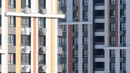 Fototapeta premium Moscow, March 19 2024, A tall building with a lot of windows and a rooftop antenna. The building is white and orange