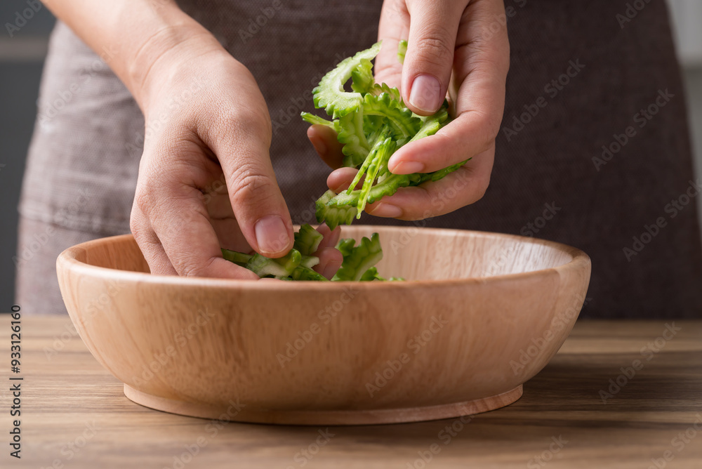 Wall mural Sliced bitter gourd in bowl with hand prepare for cooking