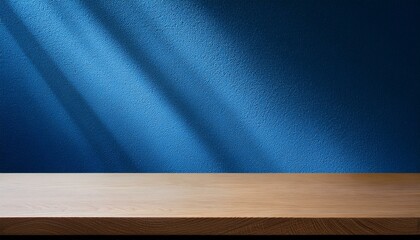 Empty table on dark blue texture wall background. Composition with organic shadow on the wall and light reflections. Mock up for presentation, branding products, cosmetics food or jewelry.