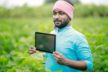 Obraz premium happy young Indian farmer using smart phone