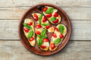 Italian mini pizza . Aubergine (eggplant ) with mozzarella cheese and basil . On rustic background