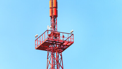 A red tower with a blue sky in the background. The tower is tall and has a red roof