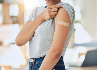 Woman, arm and vaccine with plaster for healthcare, cure or immunity in recovery at home. Closeup...