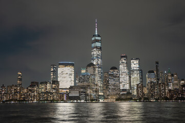 Obraz premium Night in The NYC city, USA, United States. Night day with iconic buildings. New York City NYC Manhattan Downtown Skyline, viewed from Jersey City, USA.