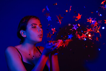 Happy Birthday. Studio portrait of girl blowing confetti. Beauty girl with confetti on birthday or valentine. Sexy model blow confetti on birthday. Sensual woman celebrating birthday wit confetti.