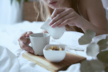 爽やかな朝に寝室のベッドでくつろぐ女性