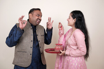 Sister tying Rakhi on her brother's wrist as they celebrate Raksha Bandhan, sharing moments of love and fun on this special day.