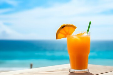 Glass of orange juice on wooden table on the beach, blue seashore background