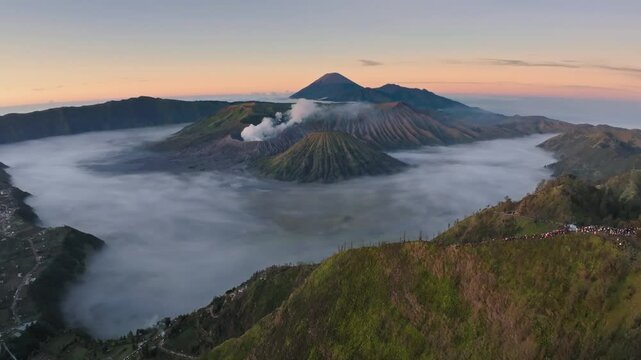 Aerial drone fly pass hill to reveal Bromo volcano, Java, Indonesia
