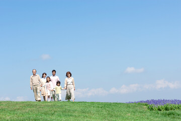 芝生を歩く三世代家族