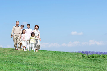 芝生を歩く三世代家族