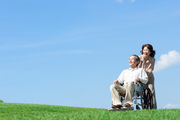 車椅子で散歩するシニア夫婦