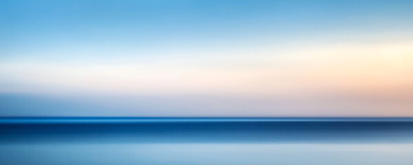 Abstract blue sky and sea, with a gradient from light to dark colors, creating an impressionistic effect. The horizon is blurred for depth.
