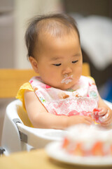 1歳の誕生日ケーキを食べる子供