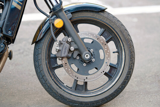 Minsk, Belarus. May 17, 2024. Detailed view of the Kawasaki Vulcan front wheel with Dunlop tire, Nissin caliper, and disc brake, engineering excellence in motorcycle safety and performance