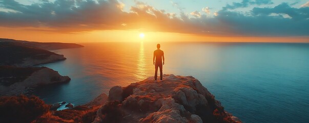 Man Standing on Cliff Overlooking Ocean Sunset - Photo