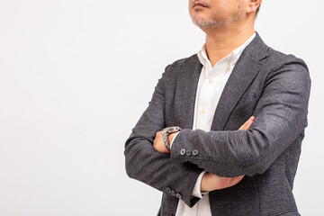 腕を組んでいる中年男性