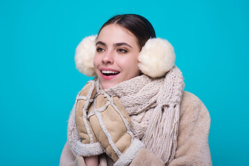 Winter portrait. Woman in winter warm hat. Portrait of happy girl in woolen clothes isolated on blue studio background. Girl in warm winter cloth. Young woman in winter knitted sweater scarf and hat.