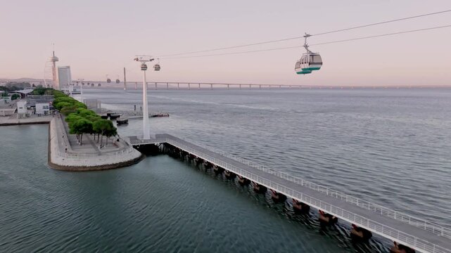 Establishing Aerial Shot of Park of Nations district in Lisbon with Tagus River and Vasco da Gama Bridge at sunset