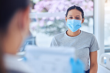 Healthcare, woman and face mask with doctor in consultation, hospital or clinic checkup. Clipboard, document and patient with medical professional for pandemic protection for covid compliance or care