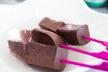 The coagulated pig's blood is cut into pieces and skewered with a stick.