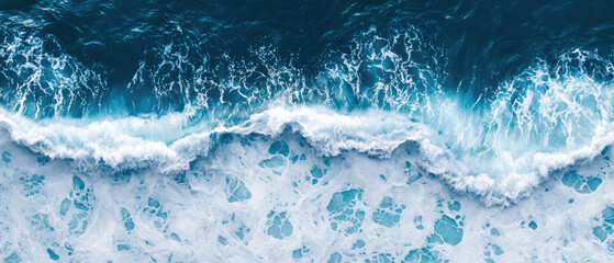 A stunning aerial view of ocean waves crashing on the shore, showcasing vibrant blue water and frothy white foam.