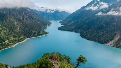 Breathtaking view of Plansee lake in Austria with hikers admiring the majestic landscape