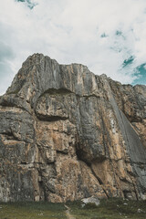 Hikers navigate the rugged terrain of the Altai Mountains, exploring magnificent rock formations under a cloudy sky