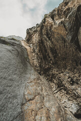 The rugged cliffs rise majestically against the sky, framing a winding trail that invites exploration within the Altai Mountains