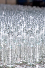 Glass factory, production of glass containers. Molten glass is blown into molds. Robotics in industry. Modern technologies, robotic machines produce products. Technological work at the plant.