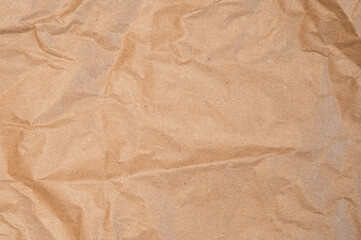 Fototapeta premium Craft wrapping paper texture of flat crumpled sheet of cellulose products. Old tattered page surface background. Eco-friendly empty aged recyclable packaging
