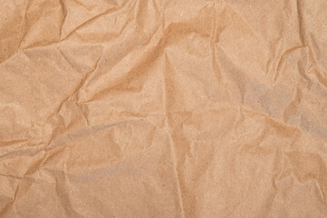 Obraz premium Brown craft baking paper sheet top view background, parchment for baking culinary, piece of wrinkled or crumpled paper texture
