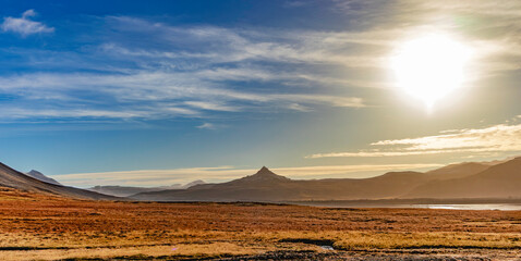 A large mountain range is visible in the distance, with a clear blue sky above