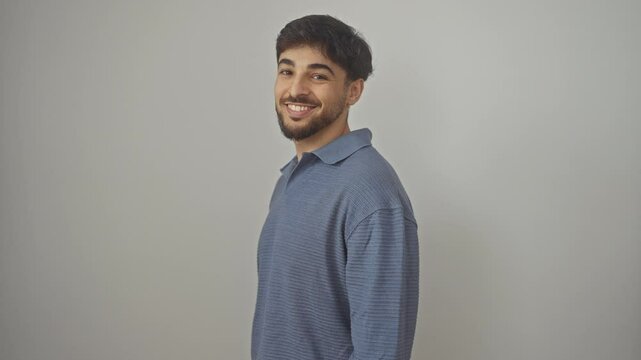 Confident young arab man with a natural smile standing in a relaxed pose, looking away over the side profile. striking a pose against an isolated white background